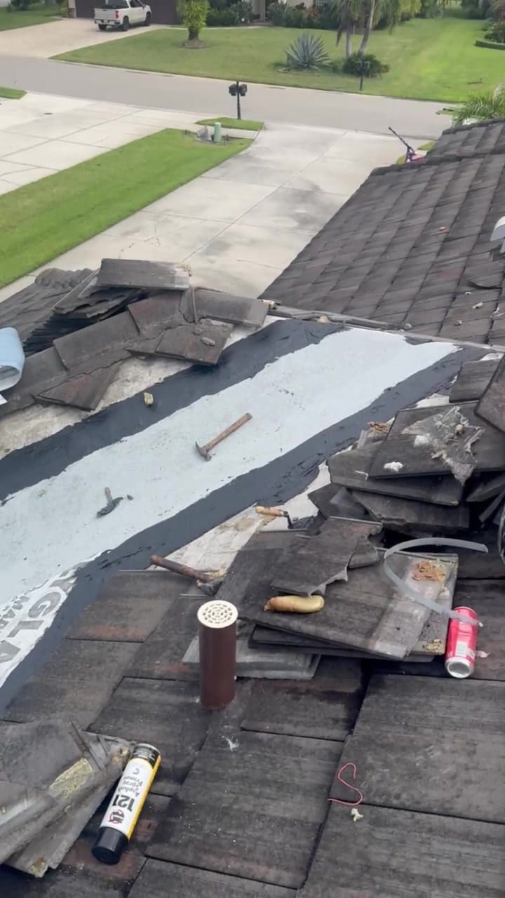 Tile roof valley opened up with fresh underlayment and flashing