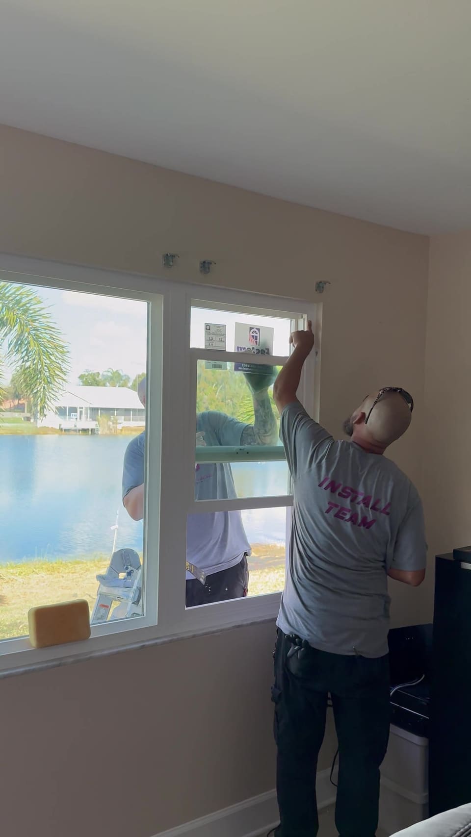 Installer finishing a new window in a lakeside home