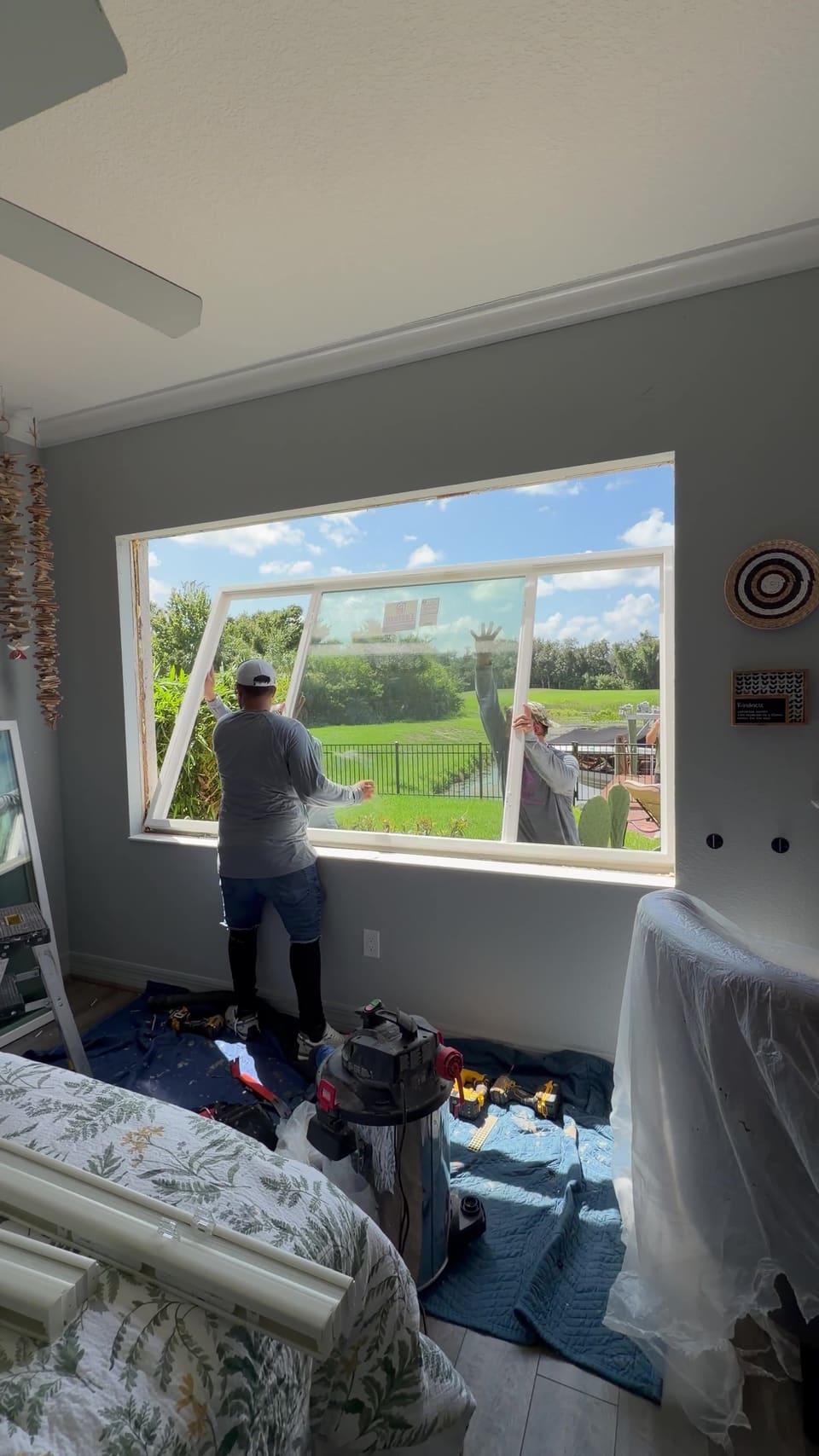 Installer fitting a new window frame from inside the room